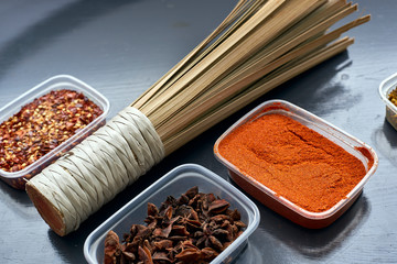 Spices in plastic containers with bamboo brush