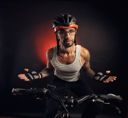 guy in a Bicycle helmet emotionally posing on a black background