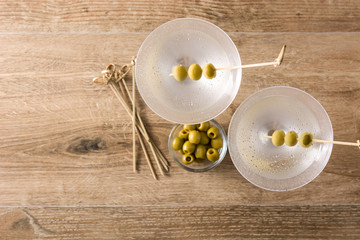 Classic Dry Martini with olives on wooden table