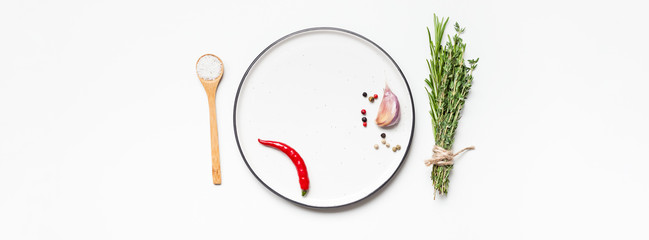 Empty plate with greens herbs and spices around