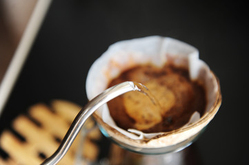 Unusual creative coconut shell pourover alternative coffee brewing drip water with gooseneck kettle close up