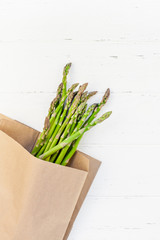 Fresh green asparagus on white wooden background