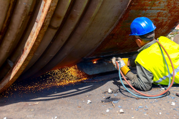 Worker is cutting old metal industrial equipment with acetylene torch