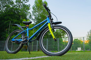 Fototapeta na wymiar blue bike on the sports ground on a sunny day