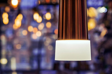 Lamp with white frosted glass on a blue background with bokeh.