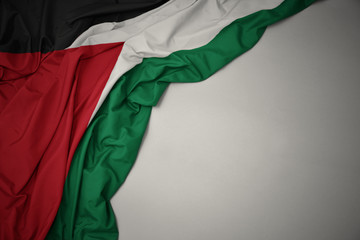 waving national flag of palestine on a gray background. - obrazy, fototapety, plakaty