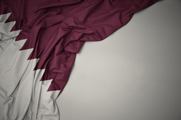 waving national flag of qatar on a gray background.