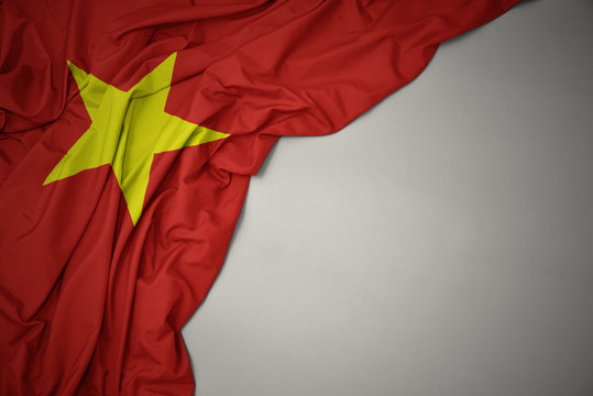 waving national flag of vietnam on a gray background.