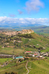 Fototapeta na wymiar Beautiful Sicilian village Calascibetta photographed from nearby Enna with adjacent mountains and green landscape. Amazing landscapes in Italy. Italian travel destinations