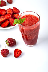 Glass of strawberry smoothie on white background