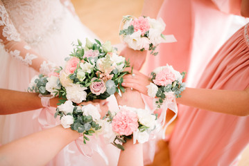 Obraz na płótnie Canvas Bridesmaids bridesmaids from flowers on their hands