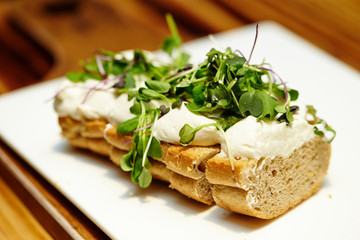 Sliced baguette with cream cheese and sprout 