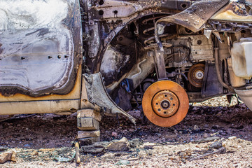 burnt car disaster effects and machines  remains with running gear in center of composition 