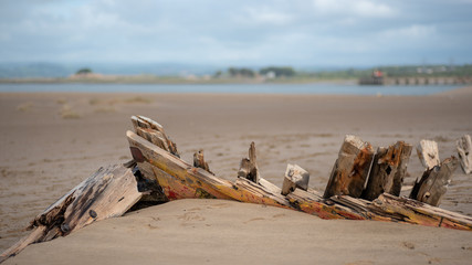 Wooden boat wreck on a sandy beach
