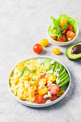 Scrambled eggs with cherry tomatoes , avocado feta cheese and olive oil.Selective focus, space for text.