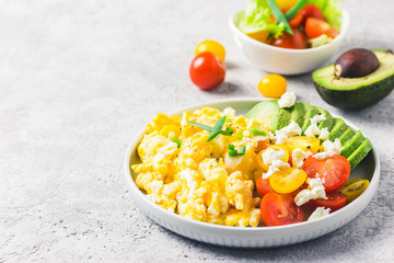 Scrambled eggs with cherry tomatoes , avocado feta cheese and olive oil.Selective focus, space for...