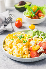 Scrambled eggs with cherry tomatoes , avocado feta cheese and olive oil.Selective focus, space for text.