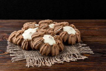 Chocolate shortbread cookies on dark wooden background.