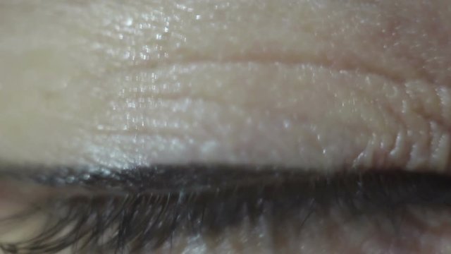 Green-brown eye of a beautiful young girl close-up. Blinking and constriction of the pupil. Macro shooting