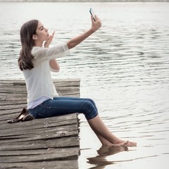young woman taking selfie - blowing kiss.
