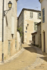Obraz premium Rue ou ruelle typique en pente récemment restaurée entre les vieux murs du centre historique de Périgueux en Dordogne