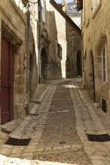 Fototapeta premium Impasse et ruelle sombres entre les vieux murs dans la quartier médiéval de Périgueux en Dordogne