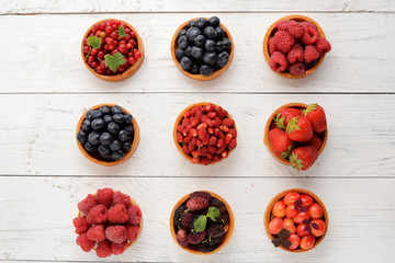 Fruit and berry tartlets dessert tray assorted . Beautiful delicious tarts, bright, colorful pastry cakes sweets with fresh raspberries, figs, strawberry. on white wooden background