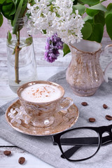 Freshly brewed coffee with a milky foam topped with cinnamon in a brown cup
