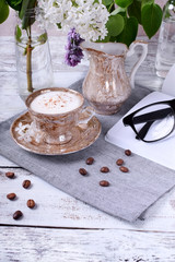 Freshly brewed coffee with a milky foam topped with cinnamon in a brown cup