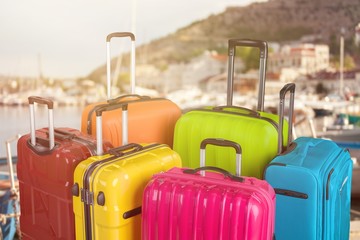 Many multi-colored big suitcases on beach background