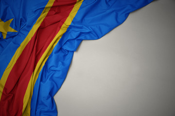waving national flag of democratic republic of the congo on a gray background.
