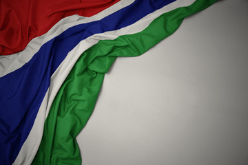 waving national flag of gambia on a gray background.