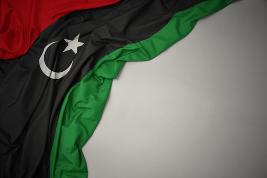 waving national flag of libya on a gray background.