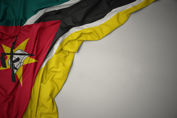 waving national flag of mozambique on a gray background.