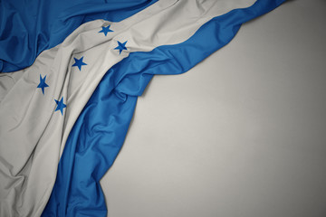 waving national flag of honduras on a gray background.