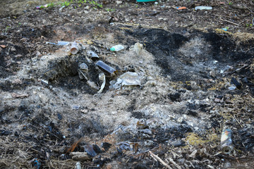 Different household waste is burned in a fire. Ecology concept and nature protection