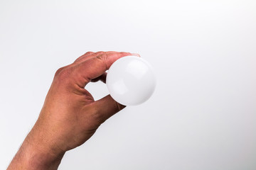 Led light bulb from top held by male hand in center on white background