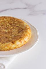 tortilla de patatas sobre plato blanco vista parcial