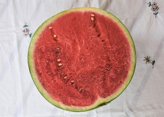Half watermelon on a white tablecloth (Citrullus lanatus)