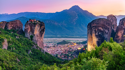 Tourist attraction to beautiful place of Meteora, monasteries on the cliffs in sunset light in...