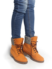 Women's legs in orange shoes and blue jeans. Clothes in casual style.