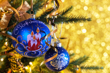 Blue Christmas balls on a gold background with bokeh