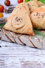 Triangle samsa meat pastry with sesame seeds on wooden board. Central Asian cuisines meal