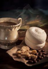 Vintage cup of coffee with homemade zephyr, pieces of brown sugar and coffee beans 