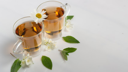 green tea with jasmine in a transparent glass thermomug on a white background