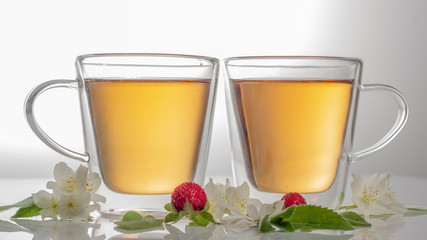 green tea with jasmine in a transparent glass thermomug on a white background