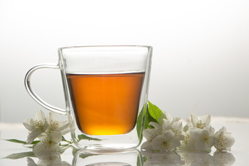 green tea with jasmine in a transparent glass thermomug on a white background