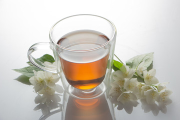 green tea with jasmine in a transparent glass thermomug on a white background