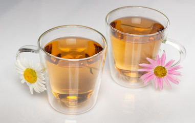 cup of herbal tea with chamomile flowers on a white table