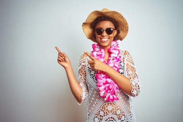 Young african american woman with afro hair wearing flower hawaiian lei over isolated background...